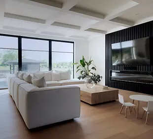 Spacious modern living room with large white sectional sofa, black slatted TV wall, floor-to-ceiling windows, and lush indoor plants – protect your dream home with comprehensive homeowners insurance from a trusted insurance agent.